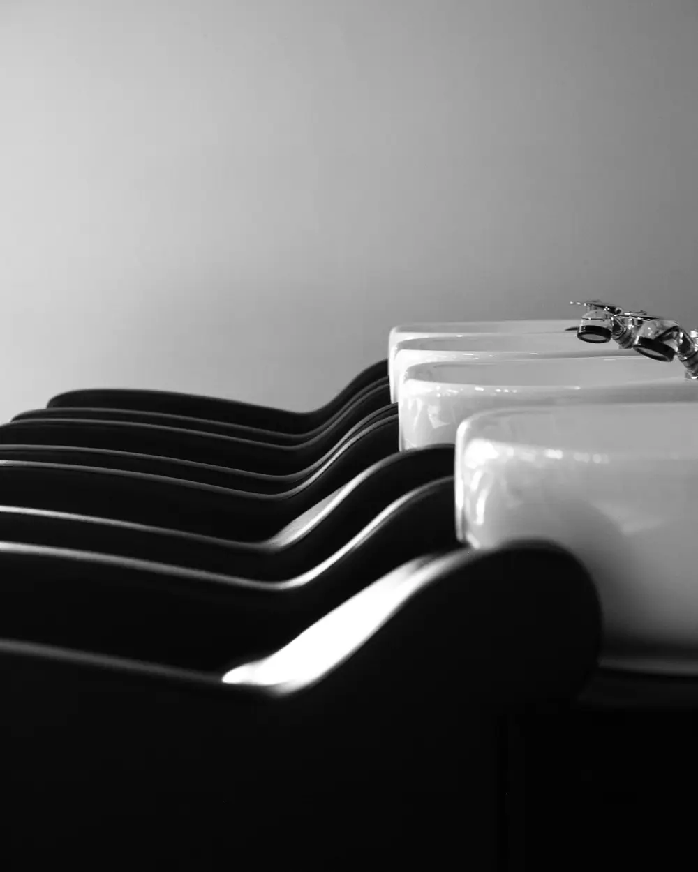 A row of white backwash basins in black and white