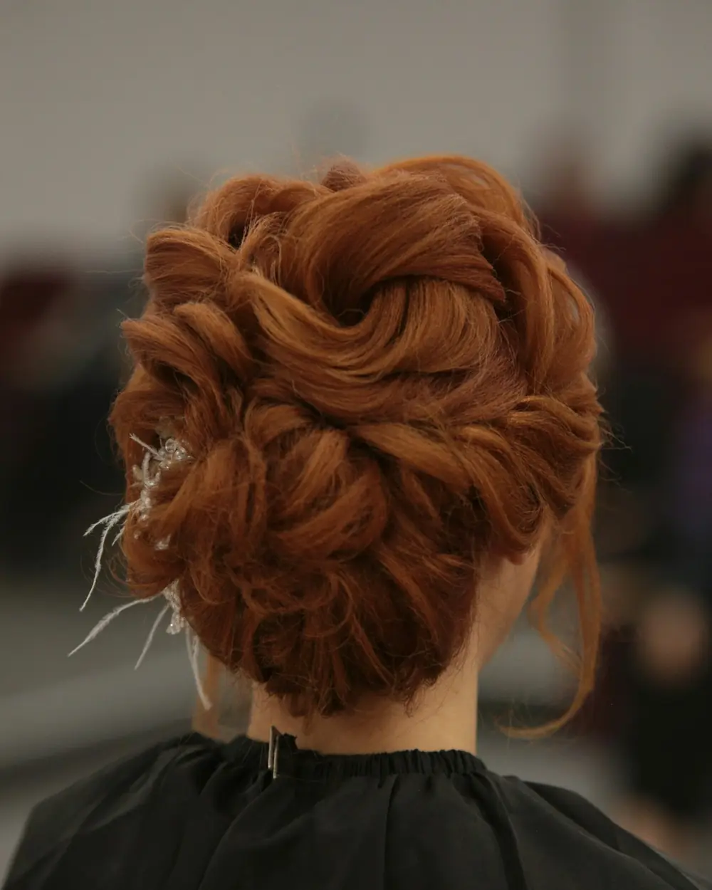 A loose copper updo, pinned at the nape